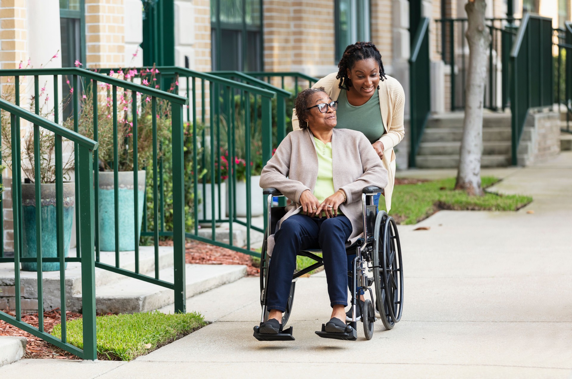 African-American senior woman in wheelchair with caregiver