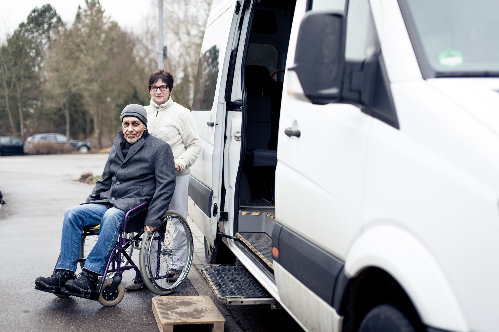 nurse helping senior man exit a van