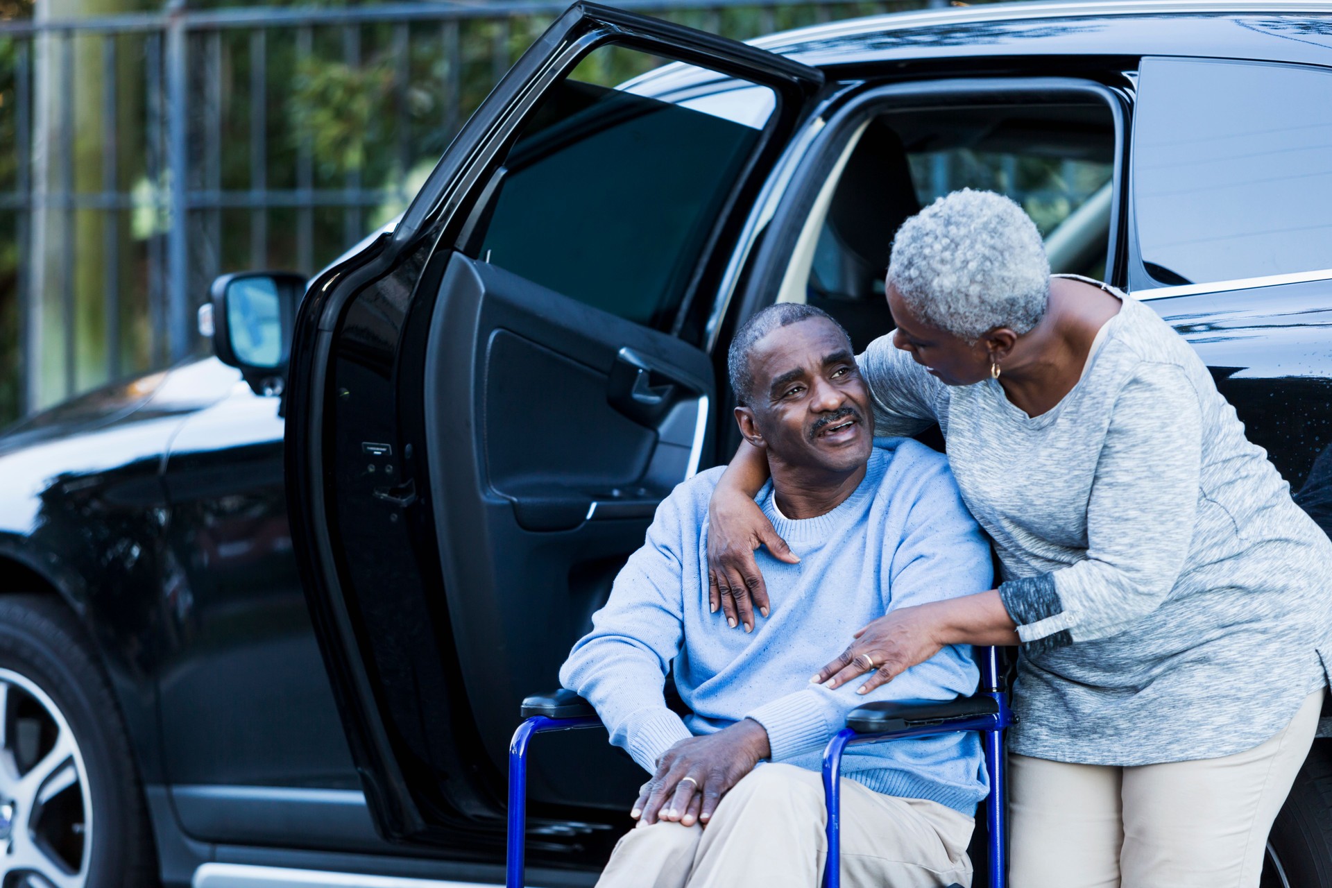 Disabled senior man in wheelchair with his devoted wife